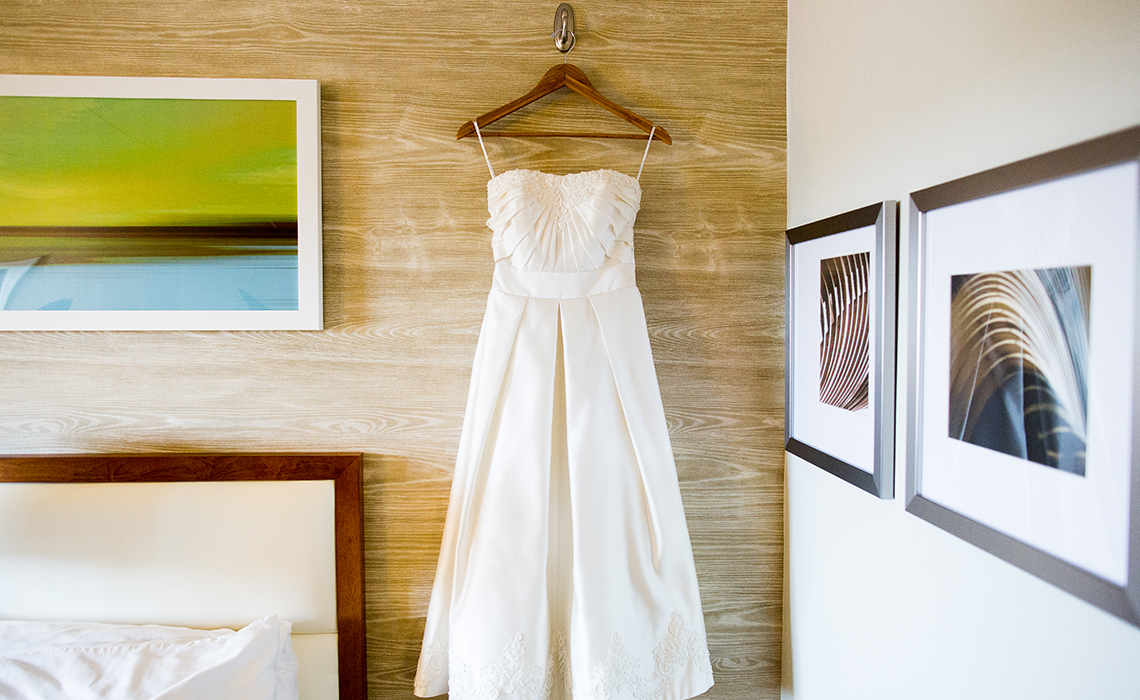 Ashley's short wedding dress hangs in her bridal suite before her Ann Arbor botanical garden wedding