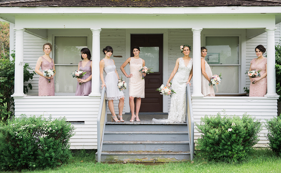 Maureen and her beautiful bridesmaids stand outside of a historical building on the grounds of the Greenmead Historical Village in Farmington Hills, Michigan.
